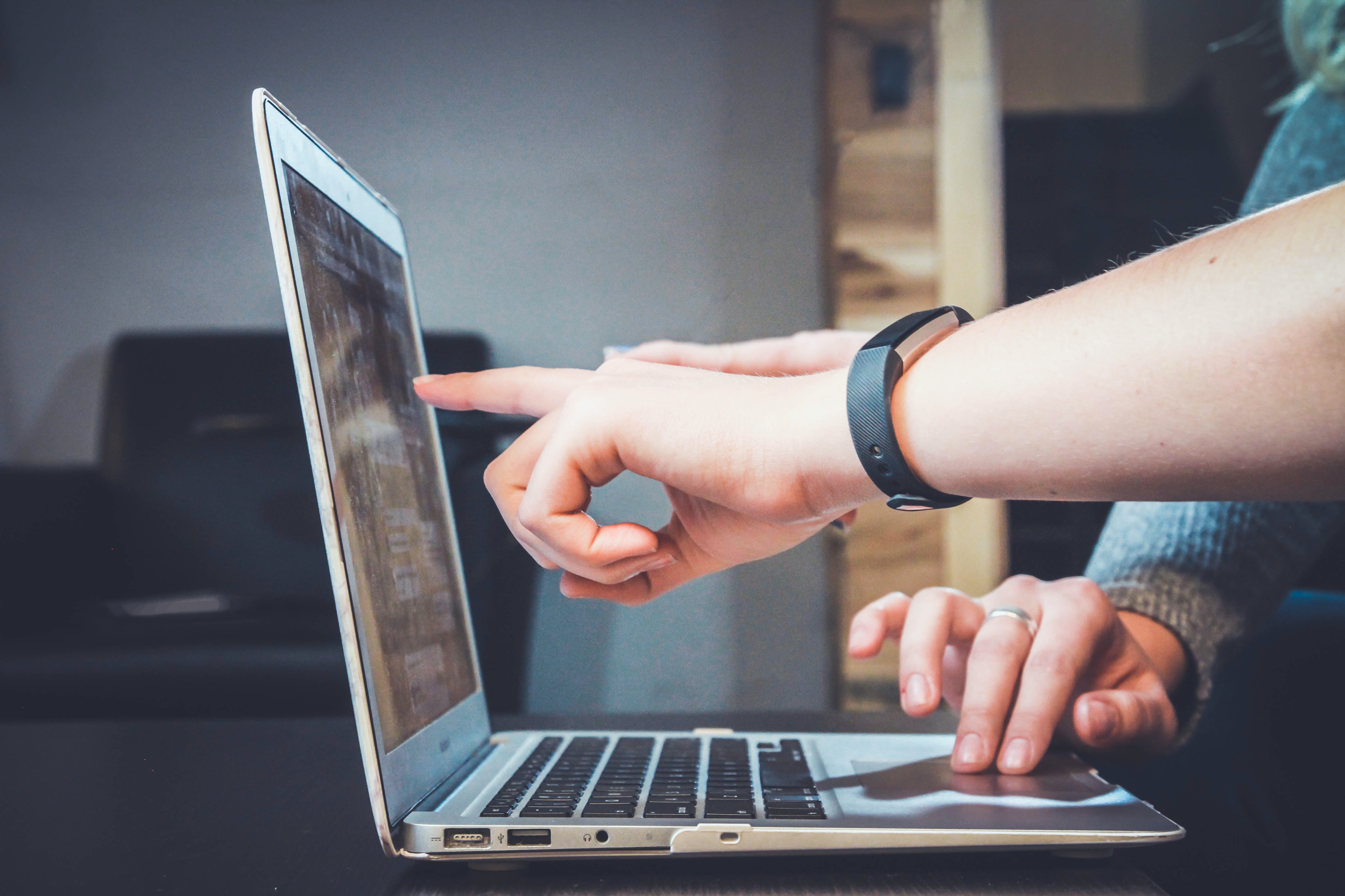 Photo of a laptop with hands typing and pointing at the screen.  This photo was taken by John Schnobrick and made available through Unsplash.com